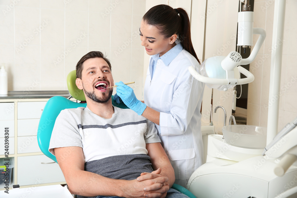 Fototapeta premium Professional dentist working with patient in modern clinic