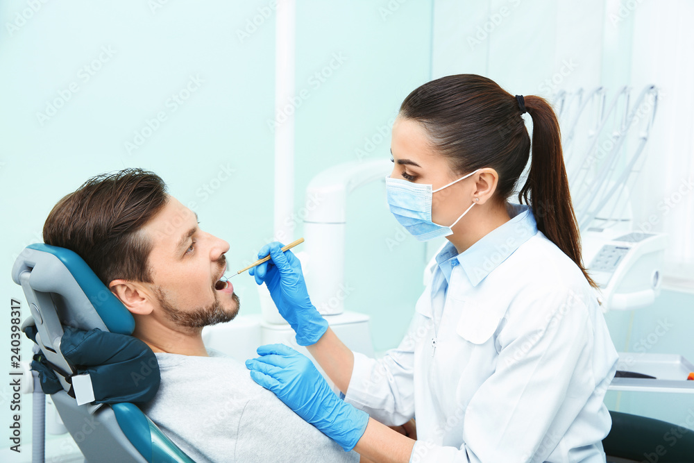 Professional dentist working with patient in modern clinic