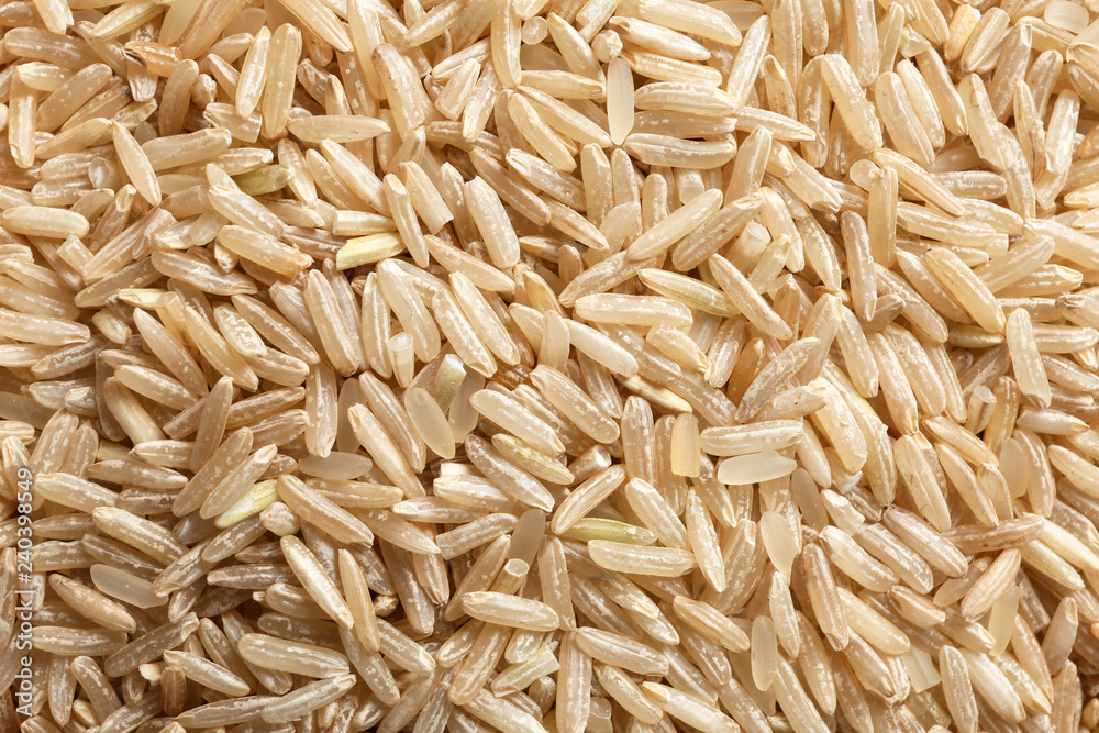 Raw brown rice as background, closeup view