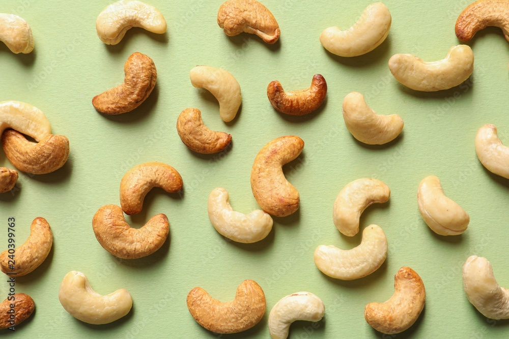 Tasty cashew nuts on color background, flat lay