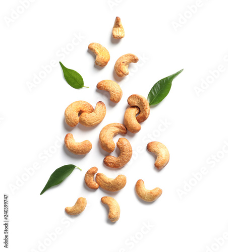 Tasty cashew nuts and leaves isolated on white, top view photo