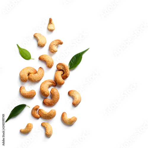 Tasty cashew nuts and leaves isolated on white, top view. Space for text