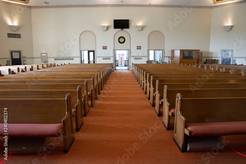 wide angle shot of interior of empty church lit by faint sunlight photo