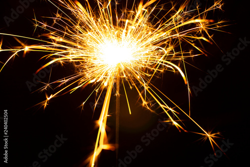 Christmas sparkler isolated on black background. Bengal fire