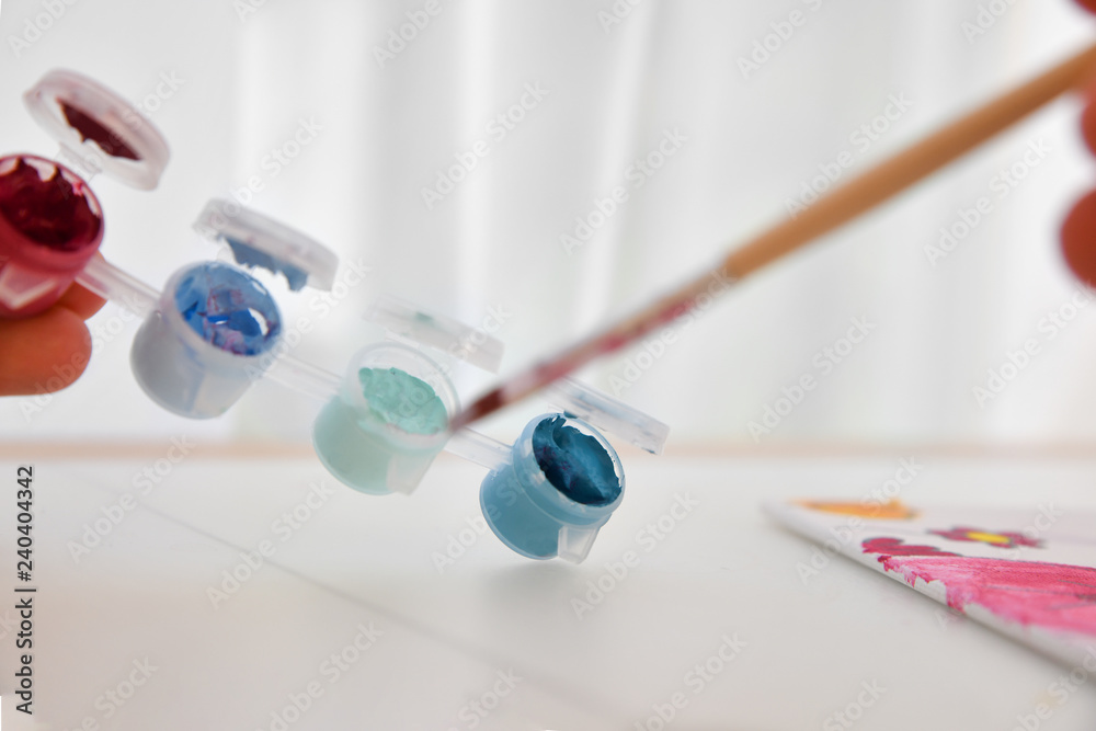 Palette with paints and water with a brush for children Palette with paints and water with a brush for children