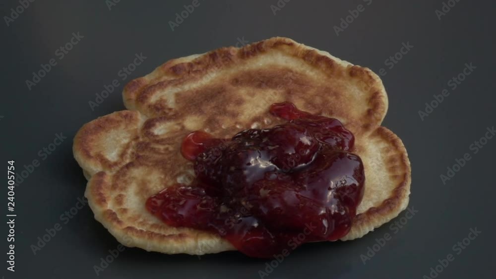 Slow motion of falling strawberry jam on batter cake close up. Appetizing natural food background with amazing texture. Home eating view. High speed camera shooting without post processing. Slow motion of falling strawberry jam on batter cake close up. Appetizing natural food background with amazing texture. Home eating view. High speed camera shooting without post processing.