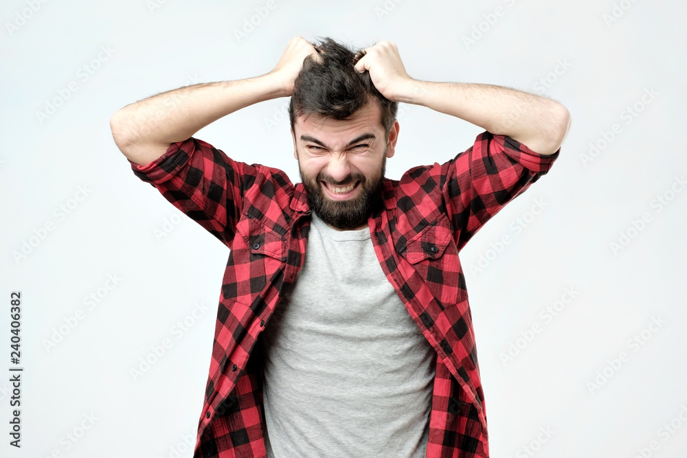 Studio shot of an angry businessman screaming and pulling his hair, Studio shot of an angry businessman screaming and pulling his hair,