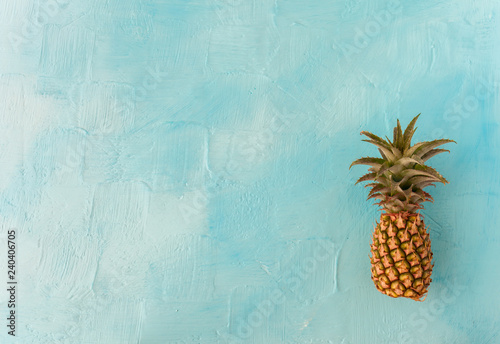 Pineapple with green stem, on blue background. Large space for text. flat layout photo
