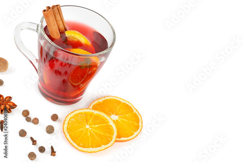 Hot red mulled wine isolated on white background with spices, orange slice, anise and cinnamon sticks. Free space for text.