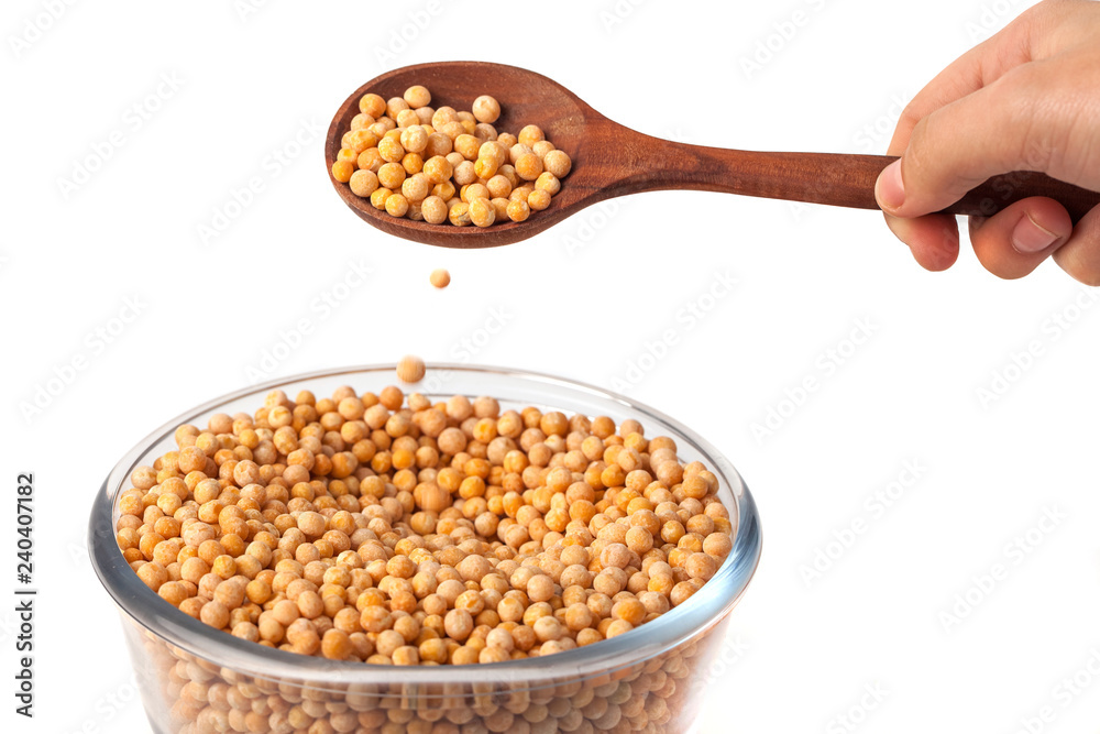 spoon in hand with yellow peas on white background. Peas in glass bowl spoon in hand with yellow peas on white background. Peas in glass bowl