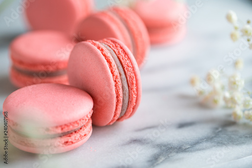 Coral cakes macarons or macaroons on white marble.