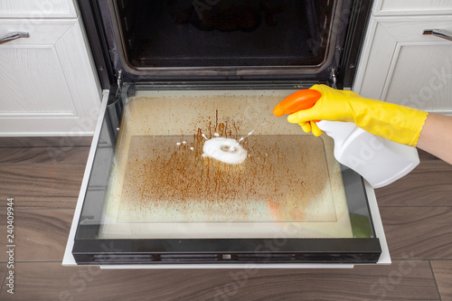 Dirty oven door in the kitchen. Cleaning and tidying.