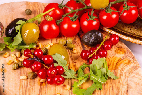 Cherry tomatoes with red currant, olives and olives with gherkins and pine nuts