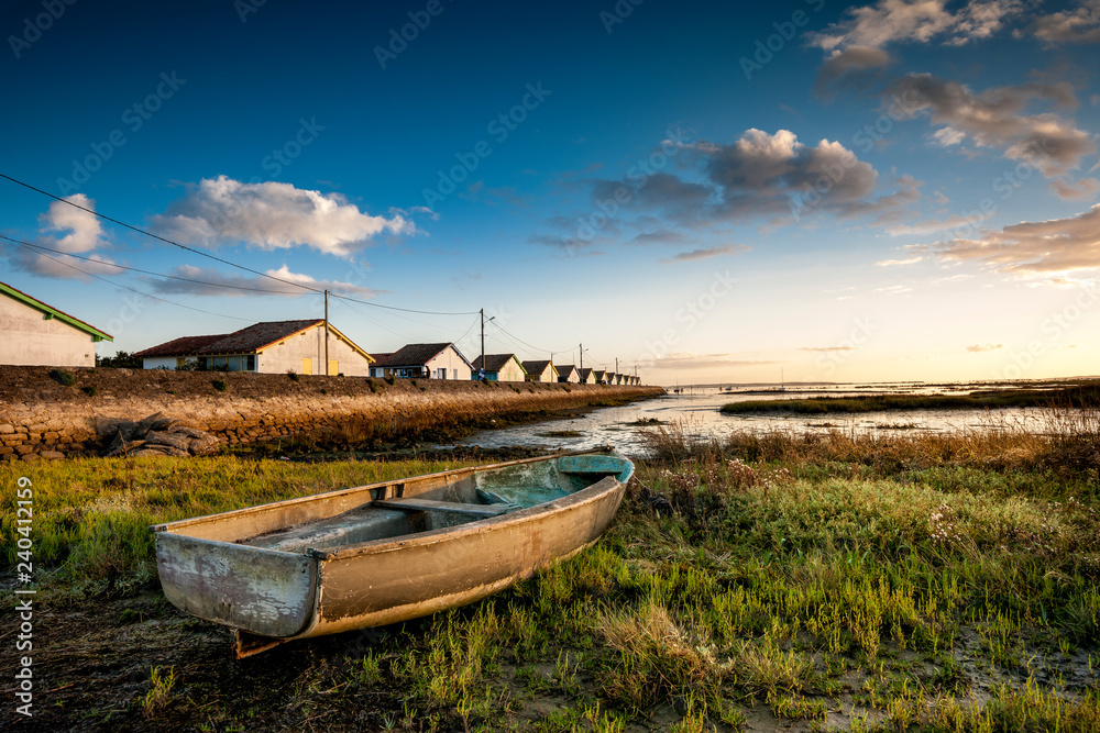 Old boat and oyster farm at sunset near Arcachon, France Old boat and oyster farm at sunset near Arcachon, France