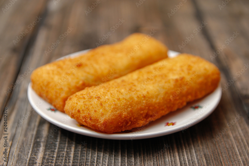 Crispy breaded fried hake fish fillet on old wooden table Crispy breaded fried hake fish fillet on old wooden table
