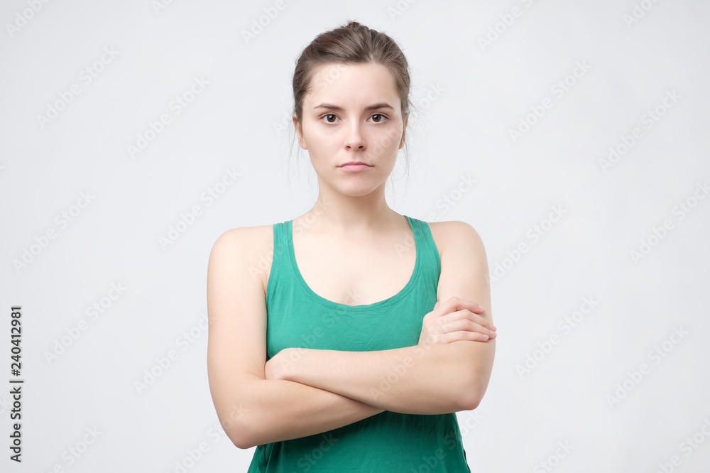Aggravated sad woman standing crossed hands expressing her dissatisfaction and disconent. Insult teenager with placid look. People and emotions concept Aggravated sad woman standing crossed hands expressing her dissatisfaction and disconent. Insult teenager with placid look. People and emotions concept