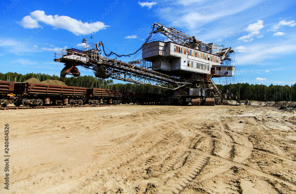 Fototapeta premium Mining machine loadind sand in train cars