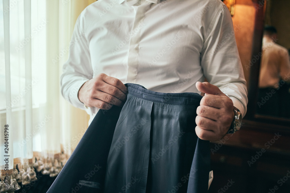 Businessman wears a jacket,male hands closeup,groom getting ready in the morning before wedding ceremony Businessman wears a jacket,male hands closeup,groom getting ready in the morning before wedding ceremony