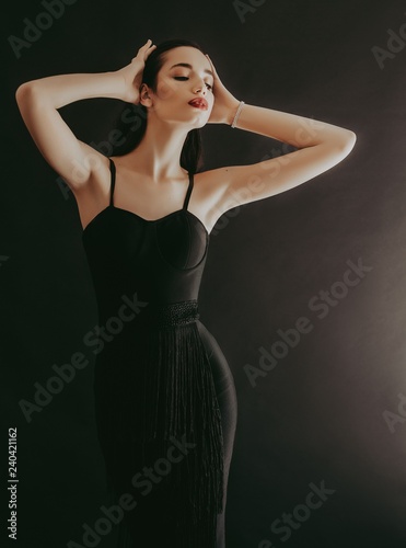 Portrait of beautiful brunette girl with makeup in fashion black clothes