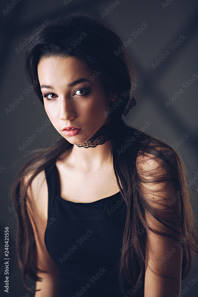 Portrait of beautiful brunette girl with makeup in fashion black clothes