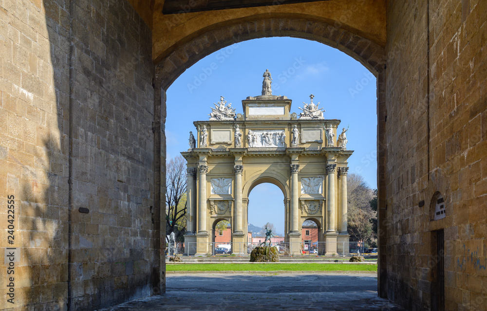 Obraz premium The triumphal arch in Florence is a monument of architecture in the neoclassical style. Nearby are the gates of St. Gall and the round fountain.