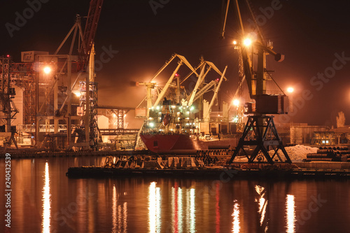 Loading grain in the port. Night panoramic view of the port, cranes and other port infrastructure.