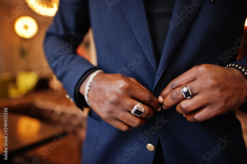 Close up hands of fashionable african american man in suit tied button.