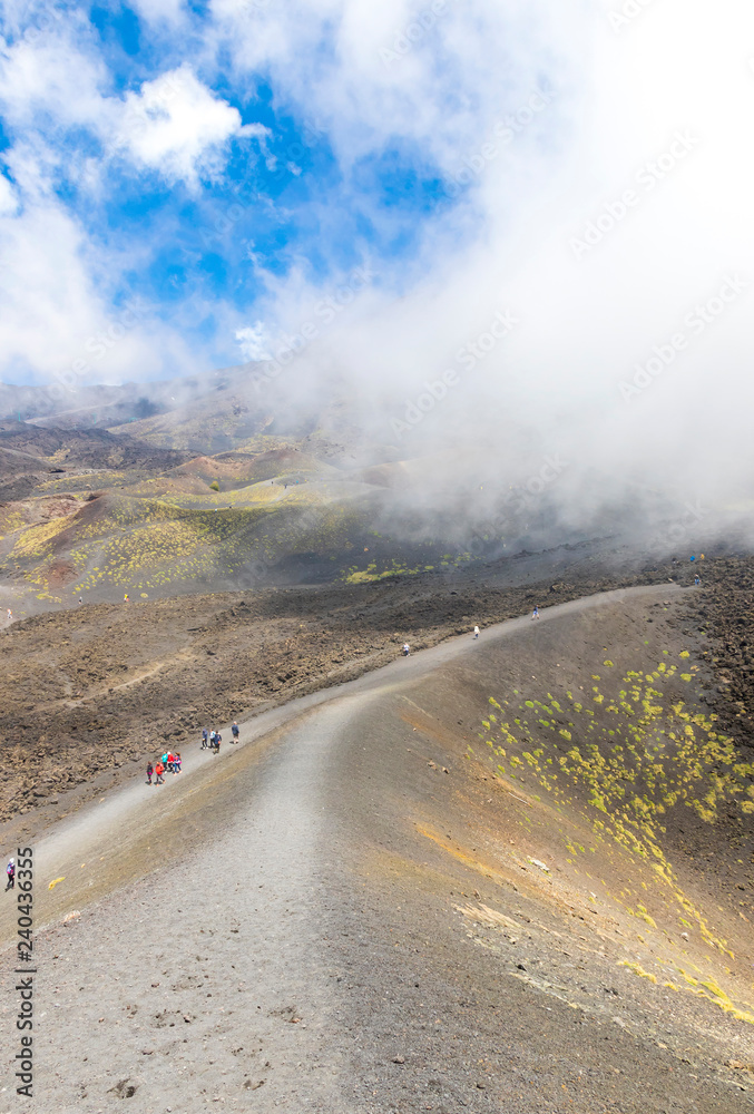 ETNA, ITALY - MAY 7, 2018: People walk to the Crater Silvestri Superiori (2001m) on Mount Etna, Etna national park, Sicily, Italy. Silvestri Superiori - lateral crater of the 1892 year eruption