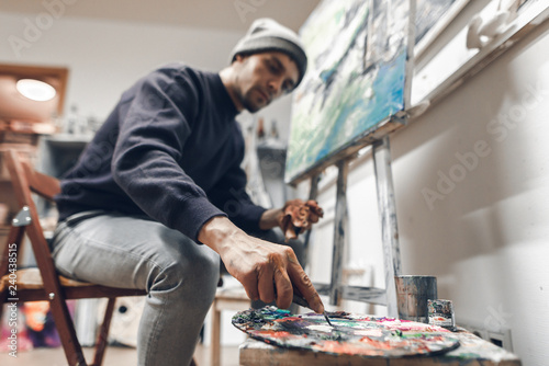 Foto Portrait of a creative man in an art studio at home, creates a picture of oil
