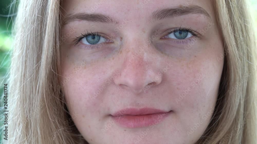 Beautiful young woman closeup portrait. Caucasian girl looking cheerful at camera, close up Beautiful young woman closeup portrait. Caucasian girl looking cheerful at camera, close up