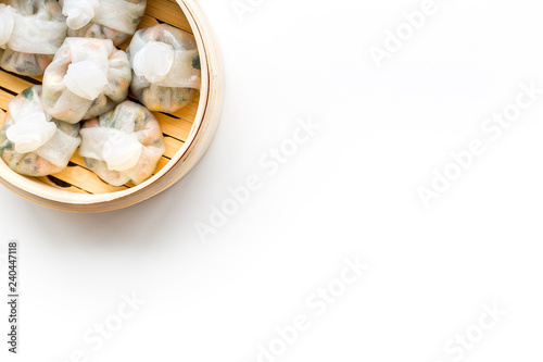 Chinese steamed dumplings Dim Sum in bamboo steamer on white background top view mock up