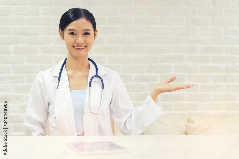 Closeup portrait of smiling beautiful female asian doctor standing with her arms crossed. Medicine representative concept on brick background. Closeup portrait of smiling beautiful female asian doctor standing with her arms crossed. Medicine representative concept on brick background.
