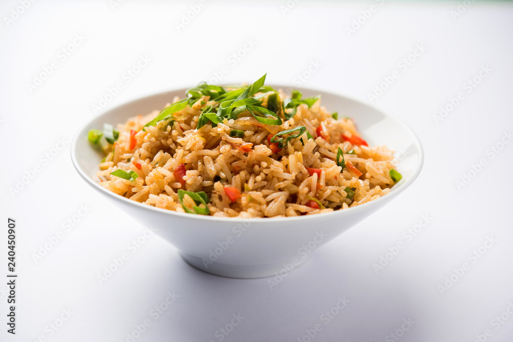 Schezwan Fried Rice Masala is a popular indo-chinese food served in a plate or bowl with chopsticks. selective focus Schezwan Fried Rice Masala is a popular indo-chinese food served in a plate or bowl with chopsticks. selective focus