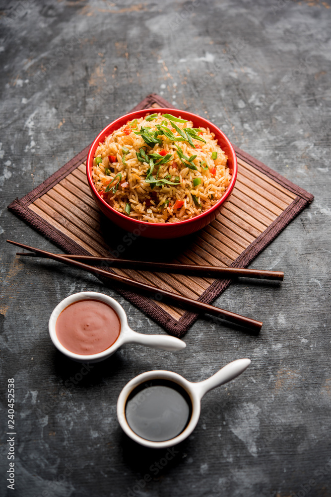 Schezwan Fried Rice Masala is a popular indo-chinese food served in a plate or bowl with chopsticks. selective focus Schezwan Fried Rice Masala is a popular indo-chinese food served in a plate or bowl with chopsticks. selective focus