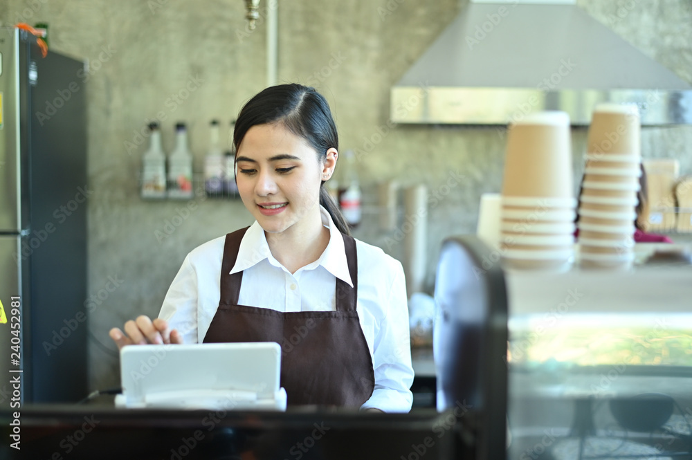Cropped shot barista using mobile ordering Kitchen System with digital tablet. Cropped shot barista using mobile ordering Kitchen System with digital tablet.