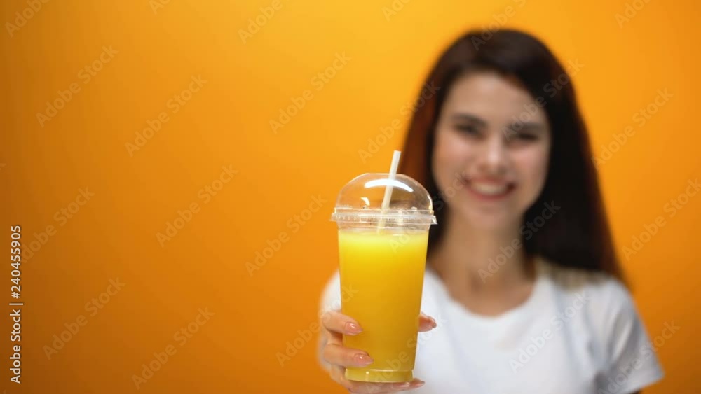 Smiling girl showing orange juice to camera, healthy refreshing drink, vitamins Smiling girl showing orange juice to camera, healthy refreshing drink, vitamins