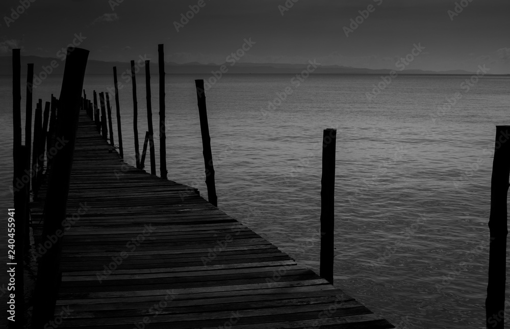 Black White Monochrome old wooden bridge cross path to sea. Concept of alone sadness walk to nowhere without destination and no one help guide the way