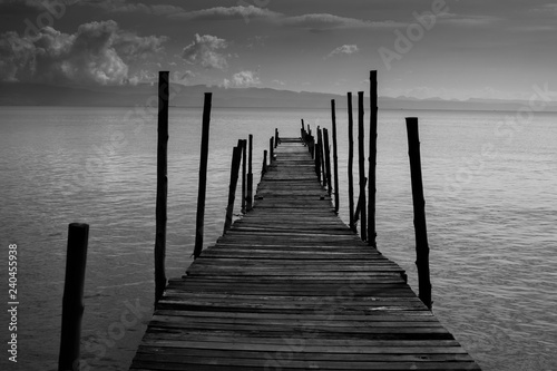 Black White Monochrome old wooden bridge cross path to sea. Concept of alone sadness walk to nowhere without destination and no one help guide the way