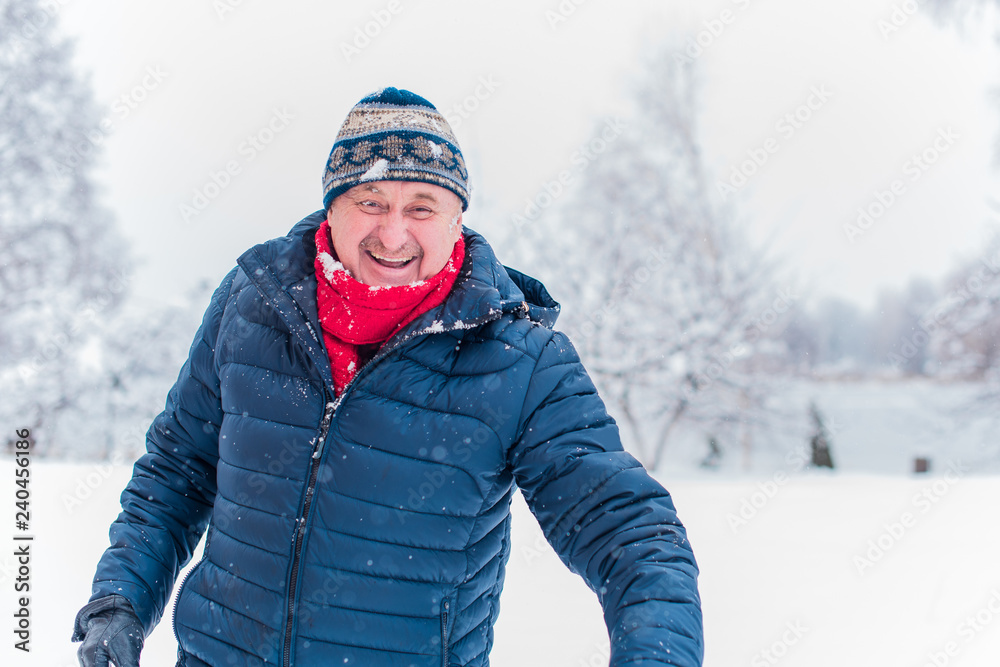 Happy senior man at winter snowy day having fun. Life of pensioner man, positive lifestyle