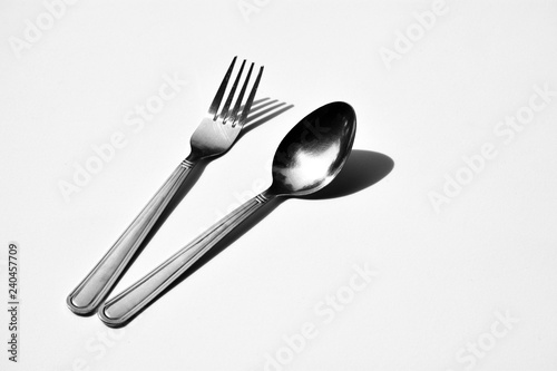 Cutlery set with fork and spoon isolated on pale white background