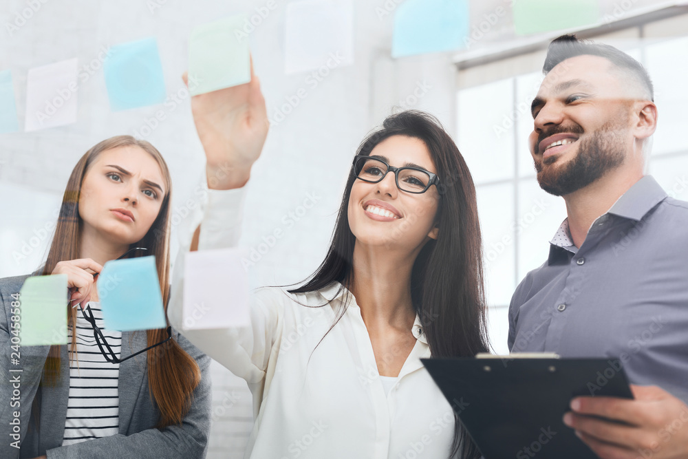 Woman brainstorming using adhesive notes on glass wall Woman brainstorming using adhesive notes on glass wall