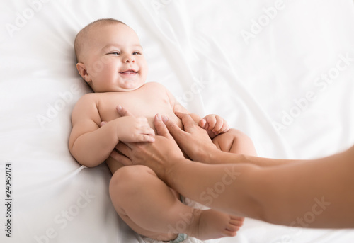 Masseur massaging tummy of baby during colic