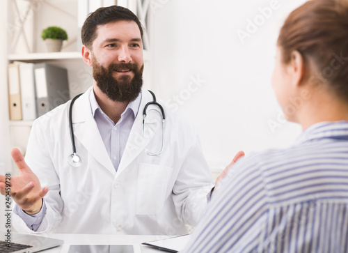 Smiling doctor talking to patient in office