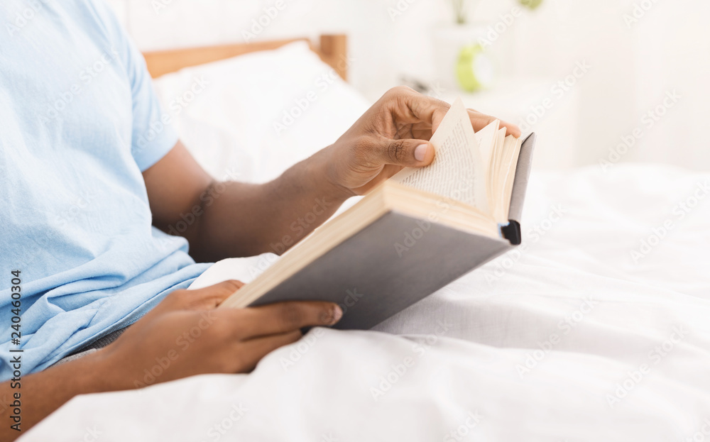 Black man studying business literature in bed Black man studying business literature in bed