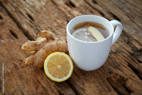 Cup of ginger tea with lemon on wooden