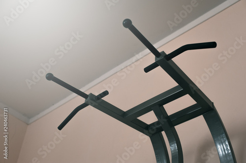 Top of a black horizontal parallel bar against the wall. Gym interior closeup of horizontal bar equipment shooted from the bottom