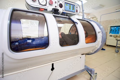 the guy in the black T-shirt lies in the hyperbaric chamber, oxygen therapy, medical room © Светлана Наклейщиков