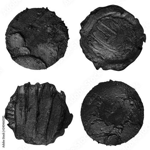 Set of four black paint samples isolated on a white background. Black round paint swatches
