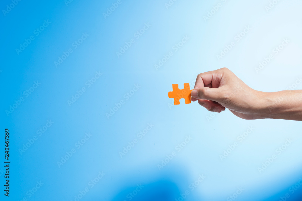 Hand holding jigsaw piece