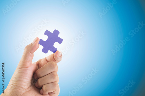 Hand holding jigsaw piece